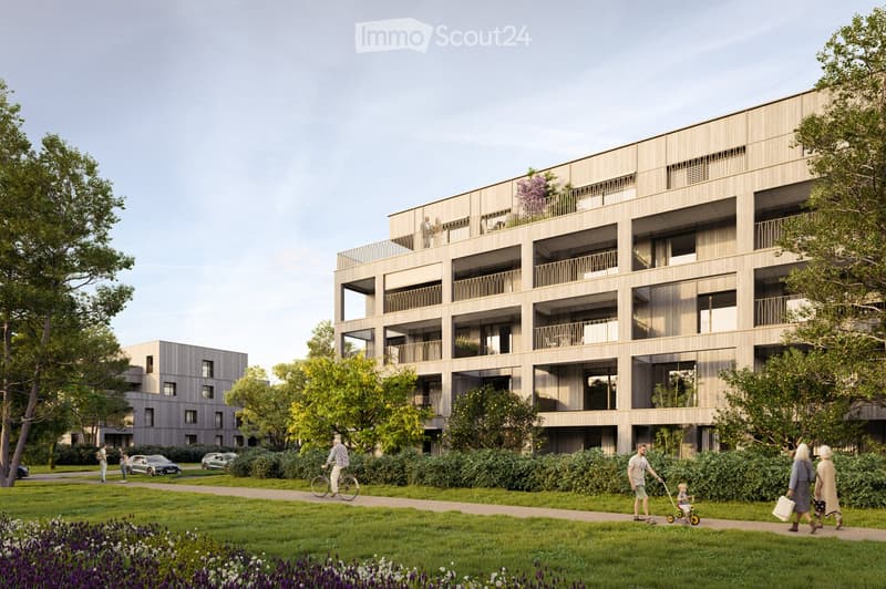 Modern multi-story residential building with balconies and large windows, surrounded by greenery and pathways.