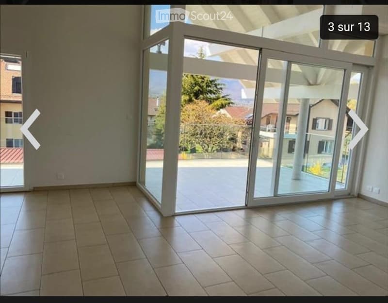 Empty room with tiled floor and large sliding glass doors leading to an outdoor area.