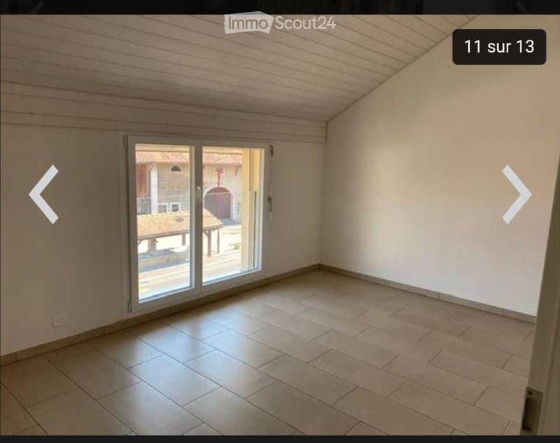 Empty room with tiled floor, white walls, and large sliding glass door leading to an outdoor area.