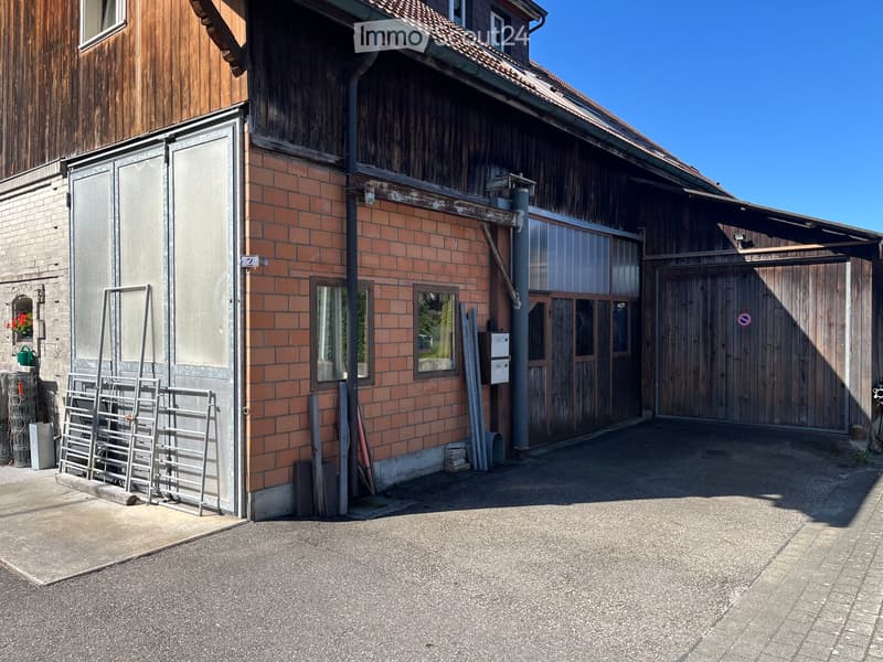 Two-story building with brick and wooden exterior, garage, and storage area.