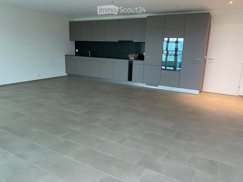 modern kitchen with gray cabinets, tiled floor, black countertop, stainless steel sink, oven, dishwasher