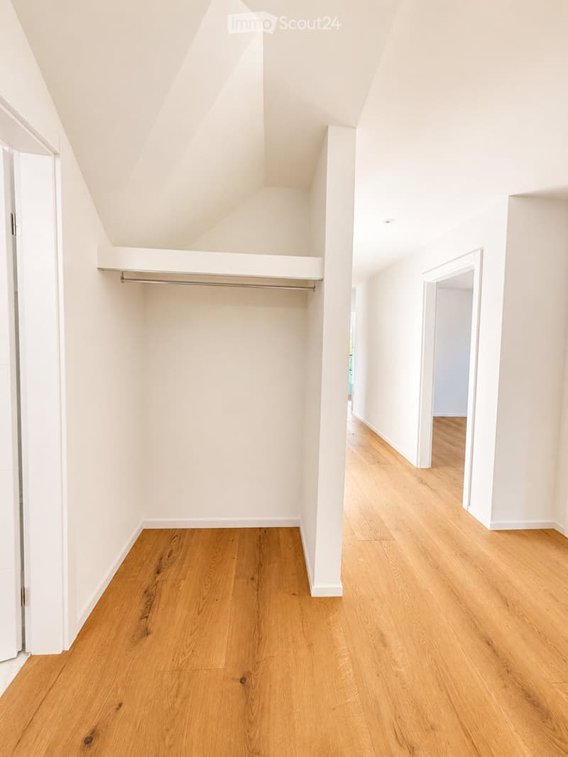 Empty room with wooden flooring, white walls, and a built-in closet with a single rod. No furniture or personal items are present.