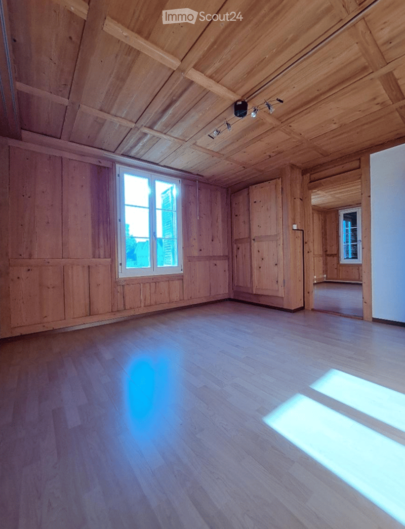 Empty room with wooden walls, wooden floor, and large windows allowing natural light to enter. No furniture or equipment is present.