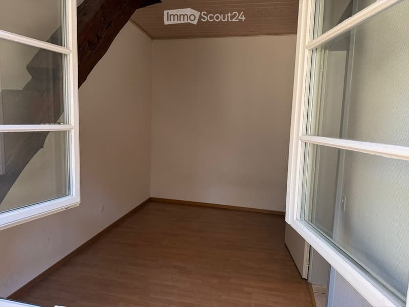 empty room, wooden floor, white walls, two windows, wooden beam