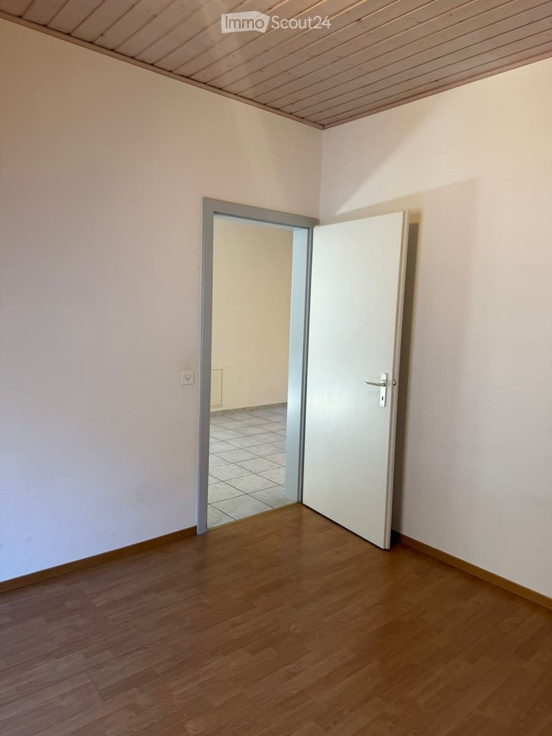 empty room, white walls, wooden floor, open door, tiled floor in the next room
