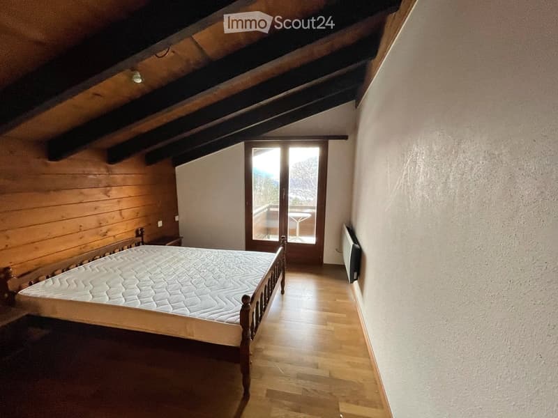 bedroom with wooden bed, wooden walls, wooden floor, glass door, balcony, heater