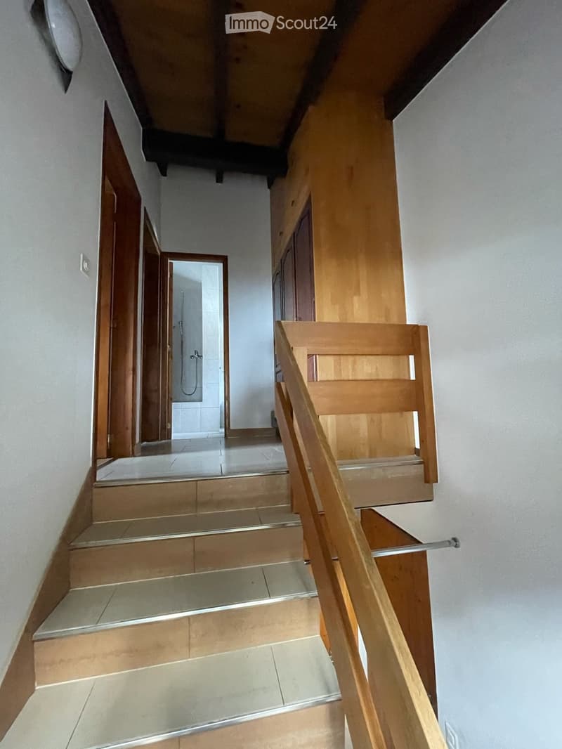 wooden staircase, tiled steps, wooden handrail, white walls, wooden doors, shower area visible