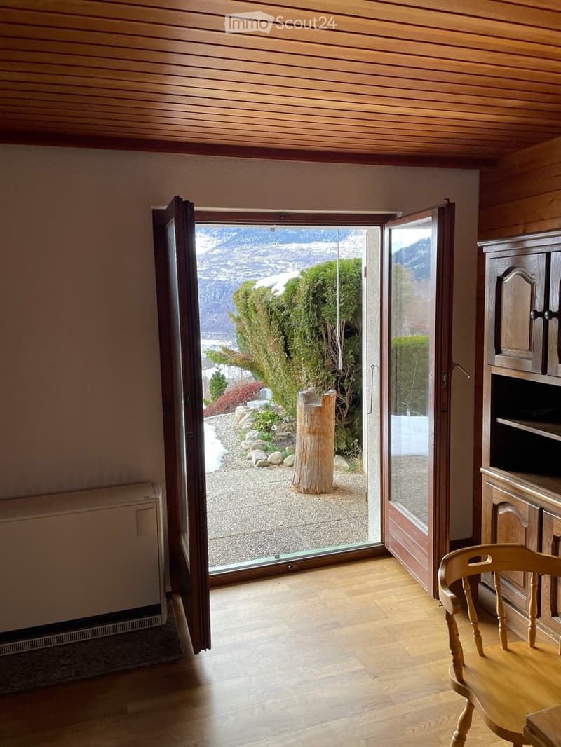 wooden floor, wooden ceiling, open door to a garden, wooden chair, wooden cabinet, heater