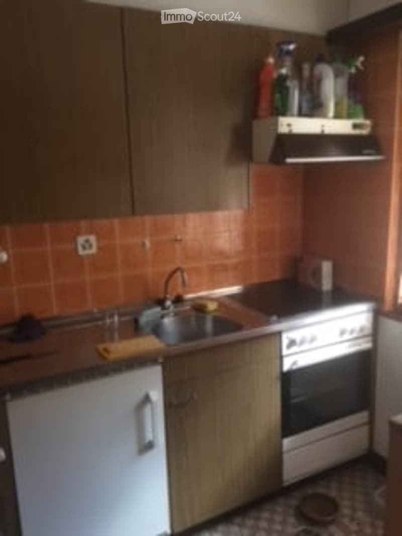 kitchen with sink, oven, washing machine, dishwasher, wooden cabinets, tiled walls