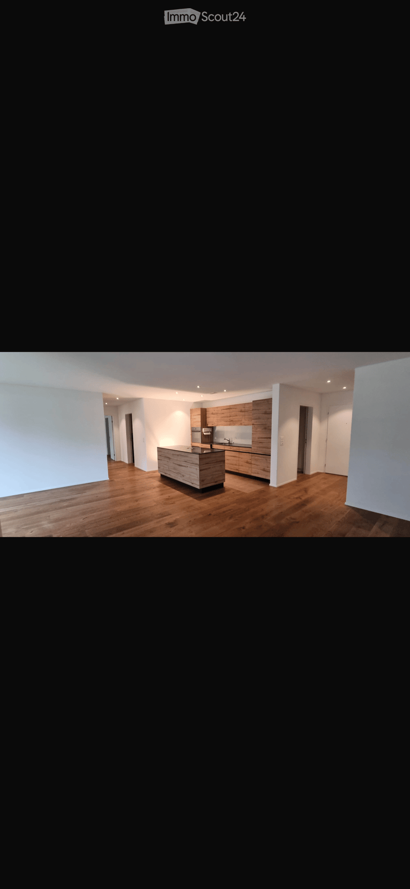 Empty kitchen area with wooden flooring, white walls, and modern cabinetry. No furniture or appliances are present.