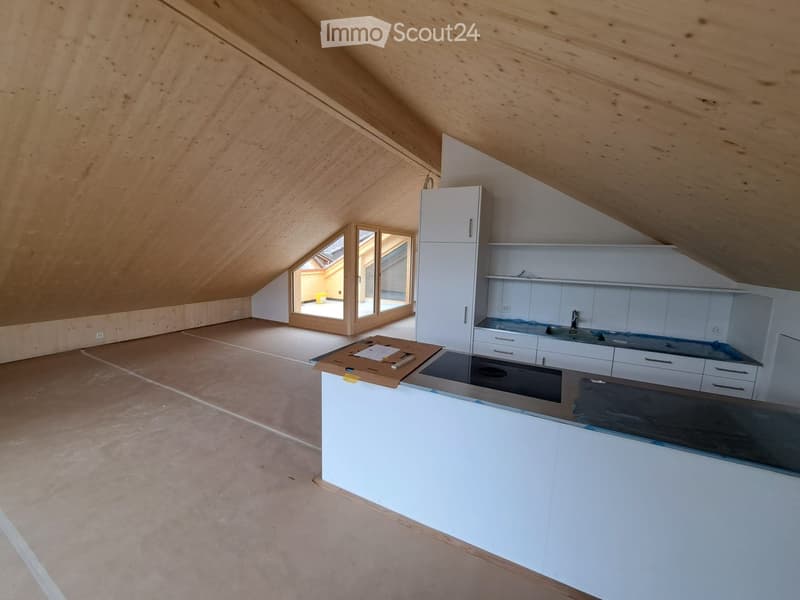 Modern kitchen with white cabinets, stainless steel sink, and countertop, featuring a skylight window and wooden ceiling beams.