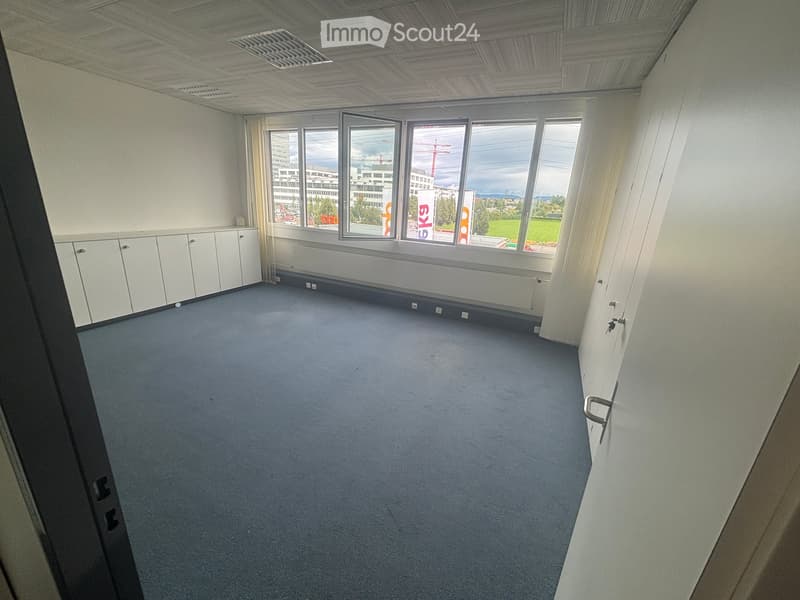 empty room, large windows, gray carpet, white cabinets, power outlets