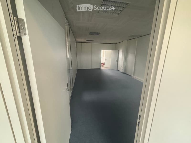 empty hallway, white walls, gray floor, open door at end