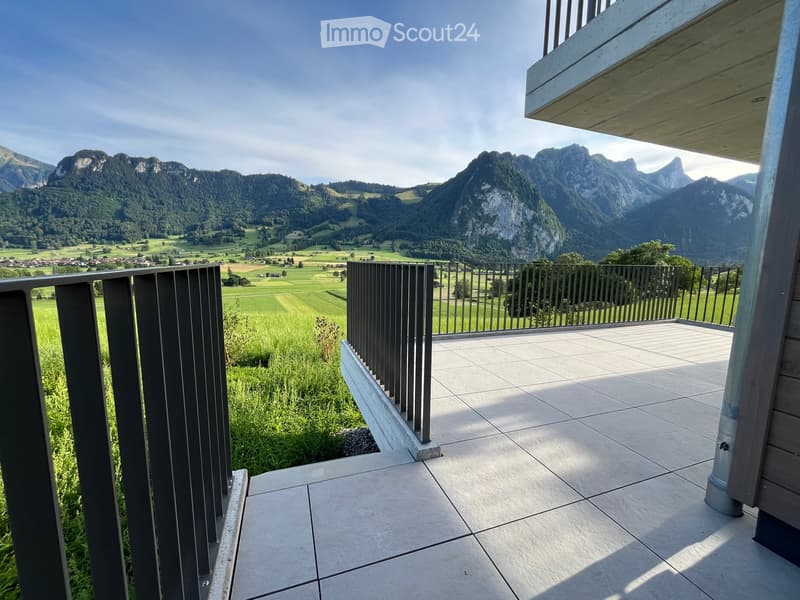 Balcony with tiled floor, wooden railing, and scenic mountain view.