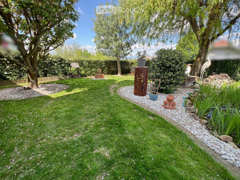 Well-maintained garden with a central lawn, gravel pathways, decorative sculptures, and various plants and trees.