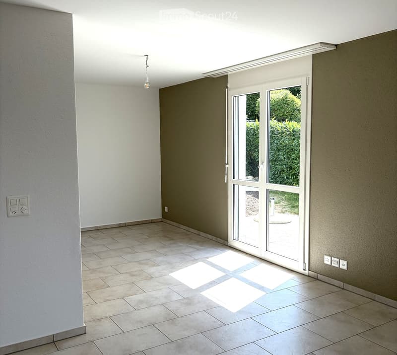 Empty room with tiled floor, white walls, and large sliding glass doors leading to an outdoor area.