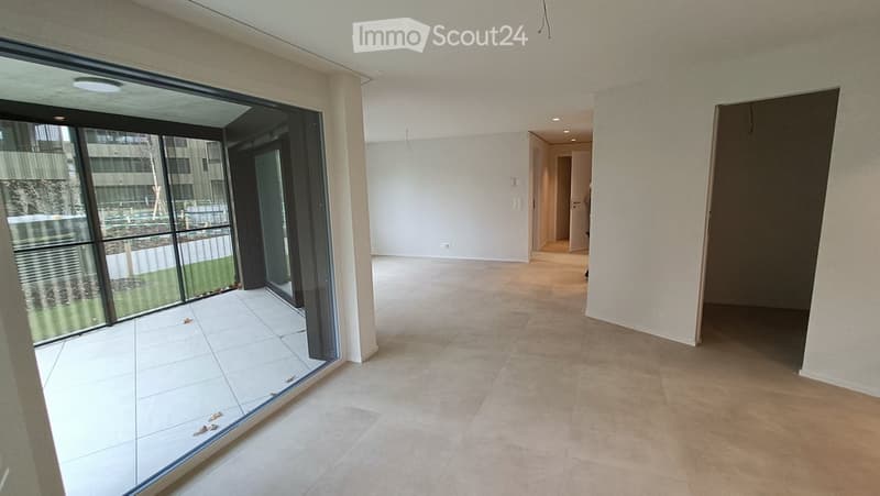 Empty room with large glass sliding doors, tiled floor, and neutral-colored walls. No furniture or equipment present.