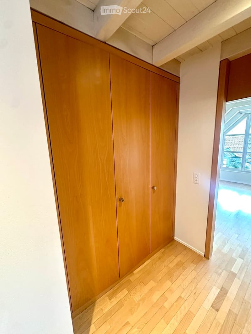 Wooden floor, wooden built-in wardrobe, white walls, white ceiling