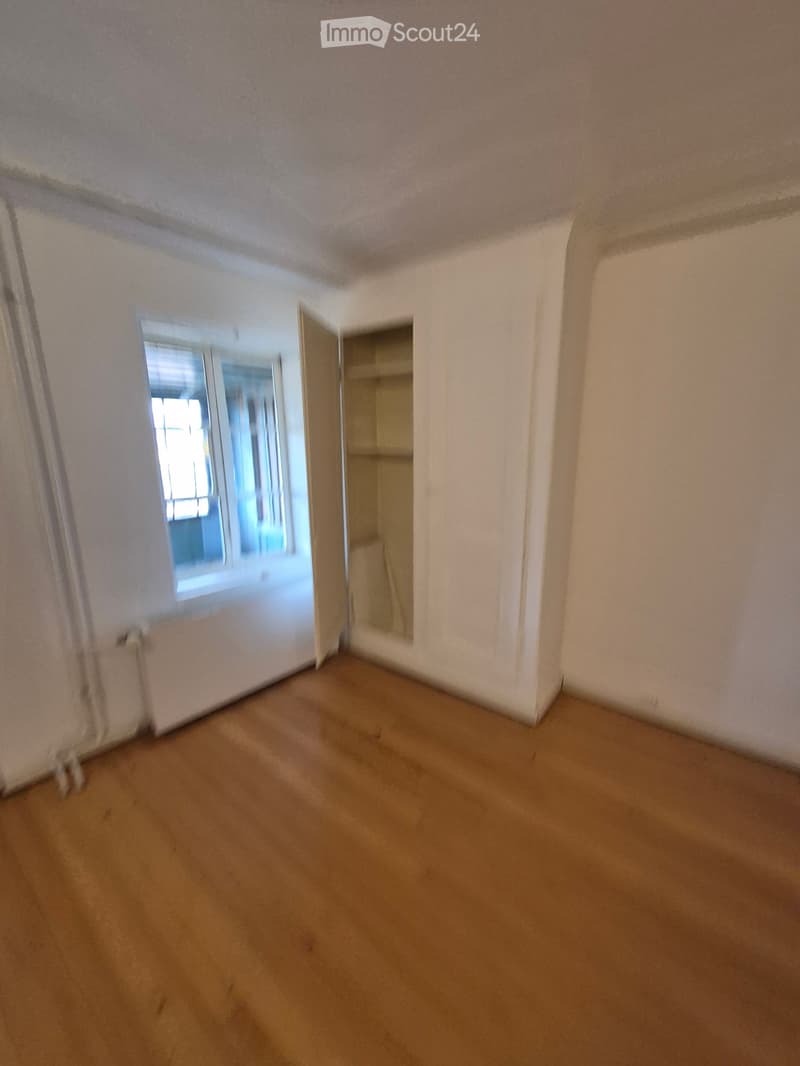 Empty room with beige carpet, white walls, and a window with blinds. No furniture or equipment present.