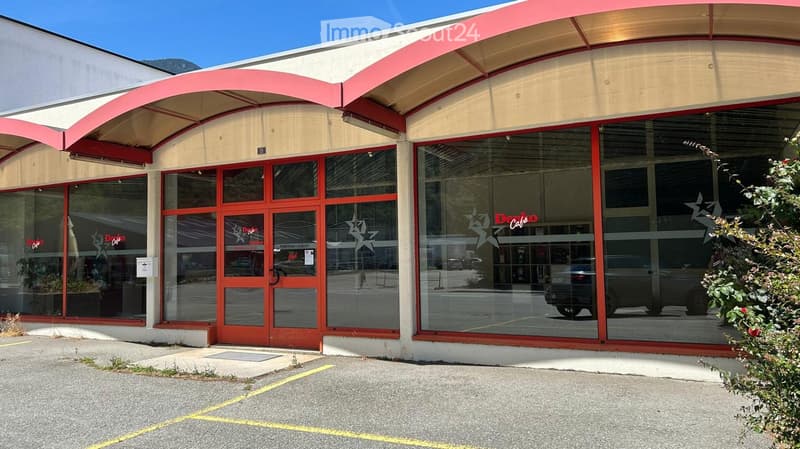 Commercial building with a red awning, large glass windows, and a sign reading "Déco Café" visible through the windows.