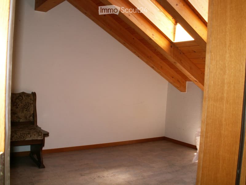 empty room with wooden floor, white wall, wooden chair, wooden ceiling with skylight