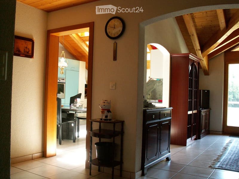 a room with table, clock, picture frame, cabinet, sofa, and vase