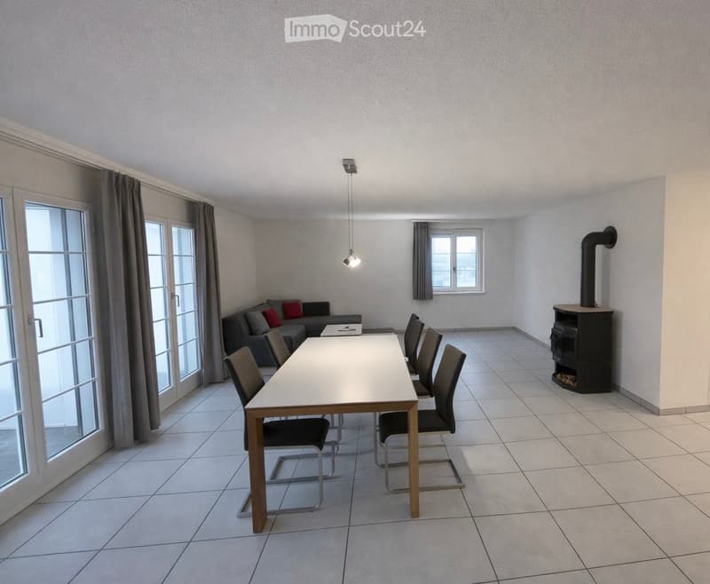 Bright room with tiled floor, large window, fireplace, sofa, dining table, and chairs.