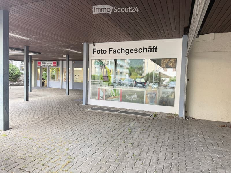 A photo shop storefront with a sign reading "Foto Fachgeschäft" and a glass display showcasing various photo frames and images.