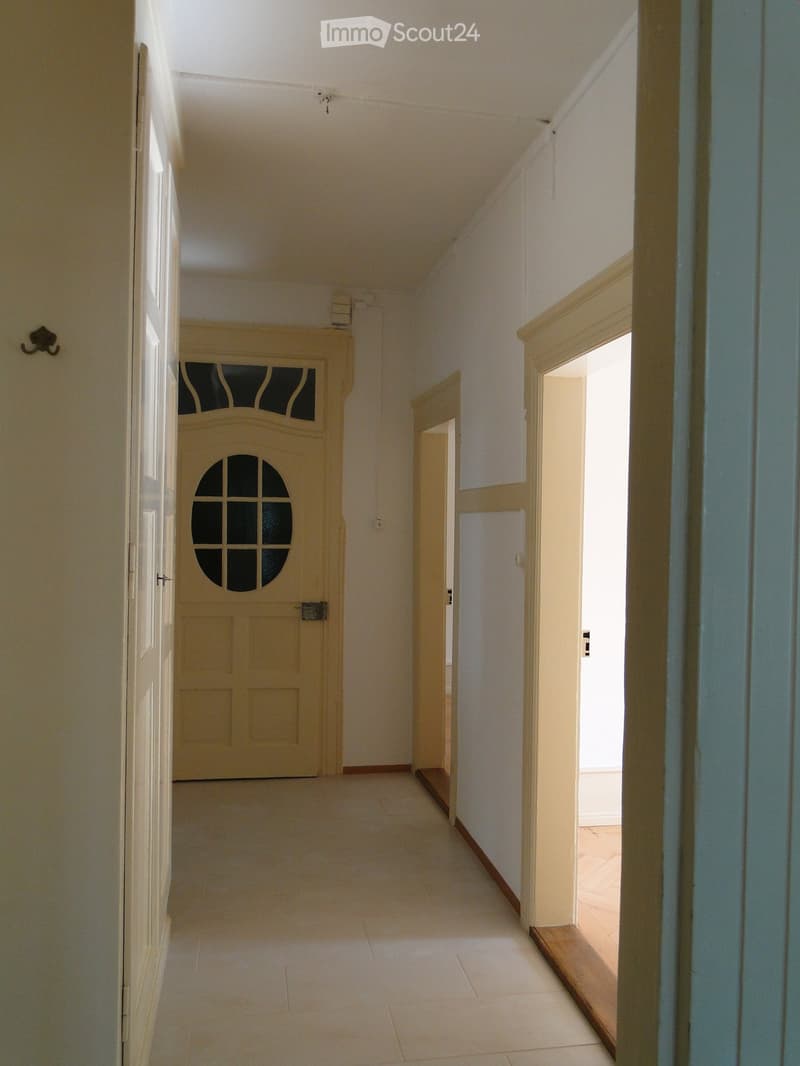 {"visible_features": [],    "type": "Room",    "description": "Wide hallway with white walls, beige ceiling, arched window in door, two open rooms",    "localized_descriptions":        {        "EN": "Wide hallway with white walls, beige ceiling, arc
