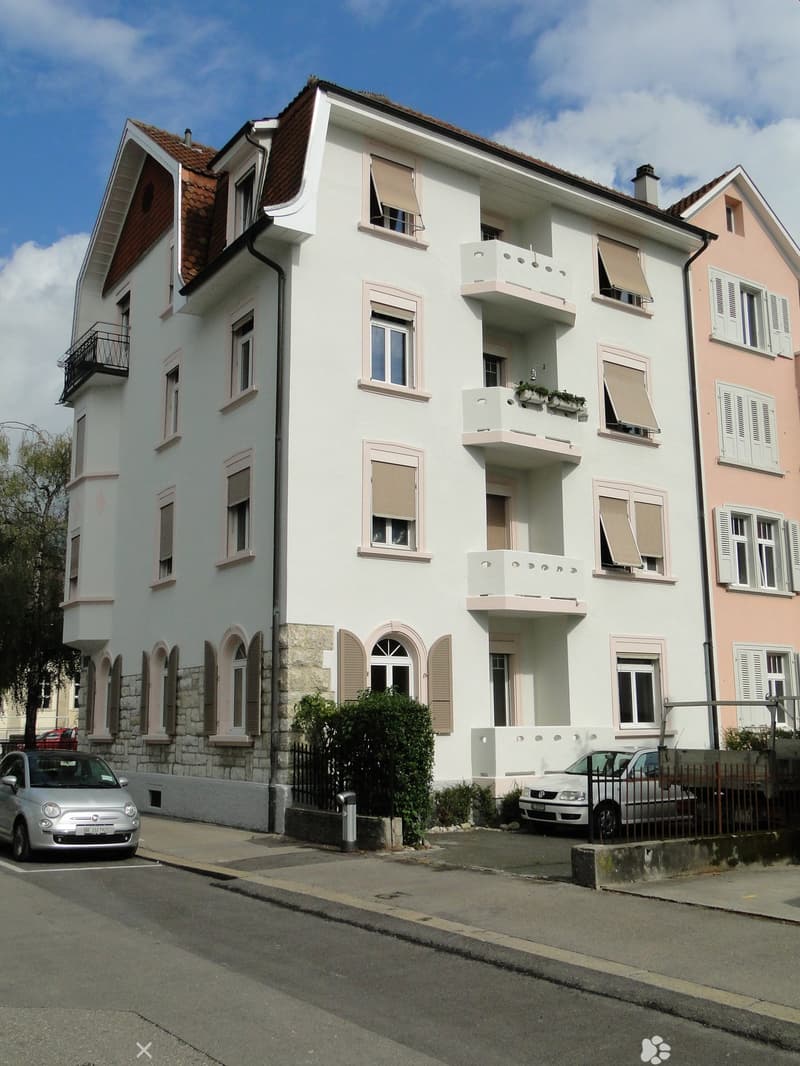 white exterior, multiple windows, stone walls, balconies, garage, parking place, cars parked