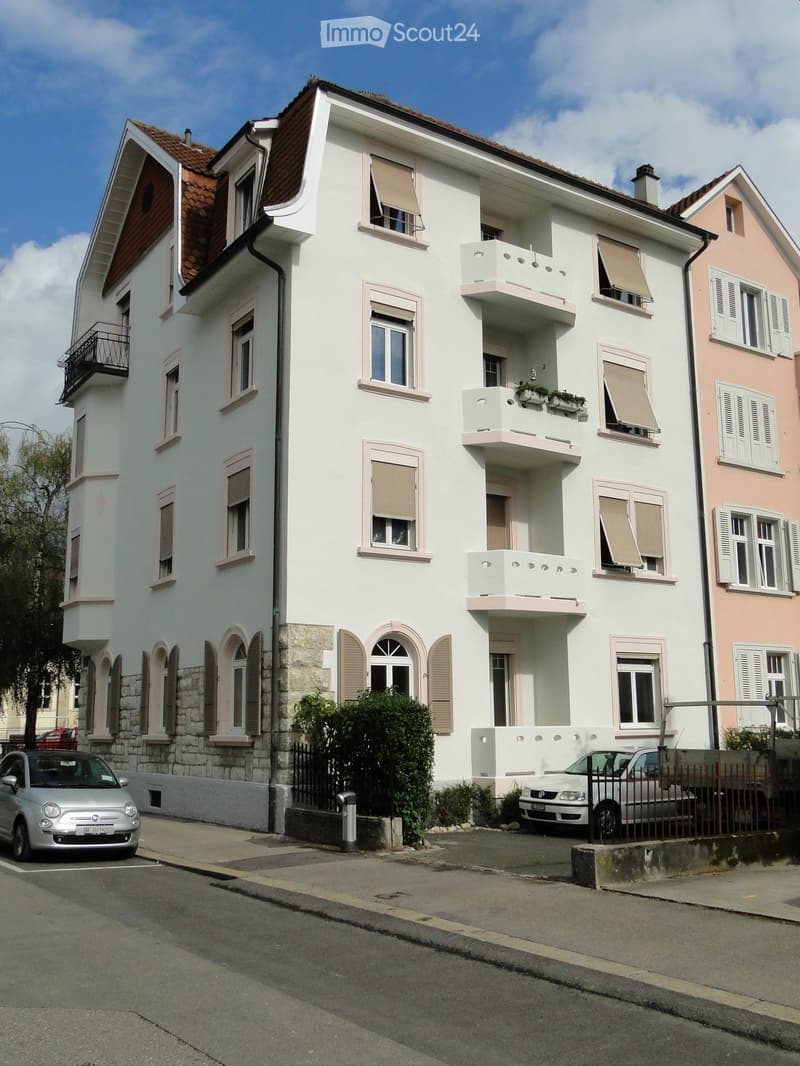 white exterior, multiple windows, stone walls, balconies, garage, parking place, cars parked