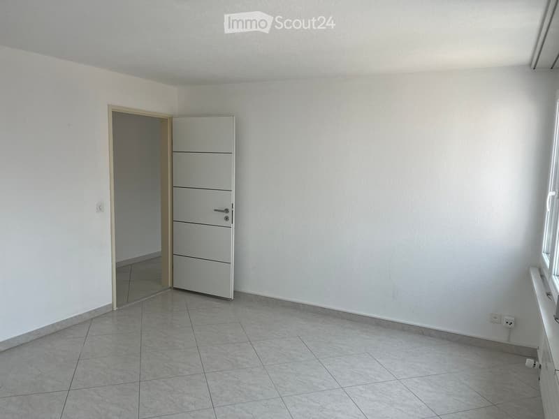 Empty room with white walls, tiled floor, and a built-in cabinet with drawers. No furniture or personal items are present.
