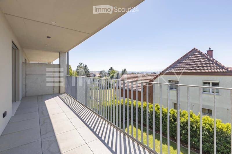 Balcony with tiled floor, metal railing, and a view of neighboring houses and greenery.