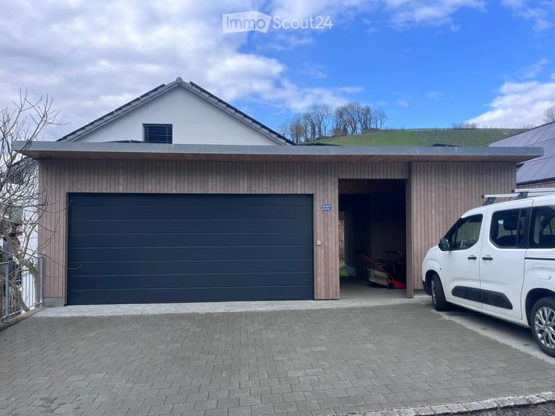 Modern two-story house with a garage, white van parked in front, and a well-maintained driveway.