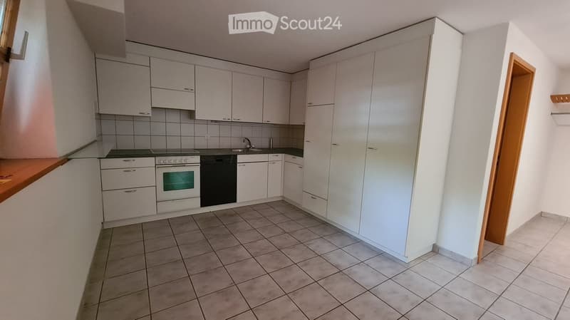 Modern kitchen with white cabinets, tiled backsplash, and stainless steel appliances including an oven and sink.
