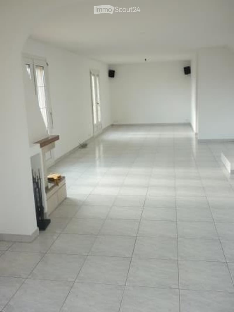 Empty room with white walls, tiled floor, and large windows. No furniture or equipment present.