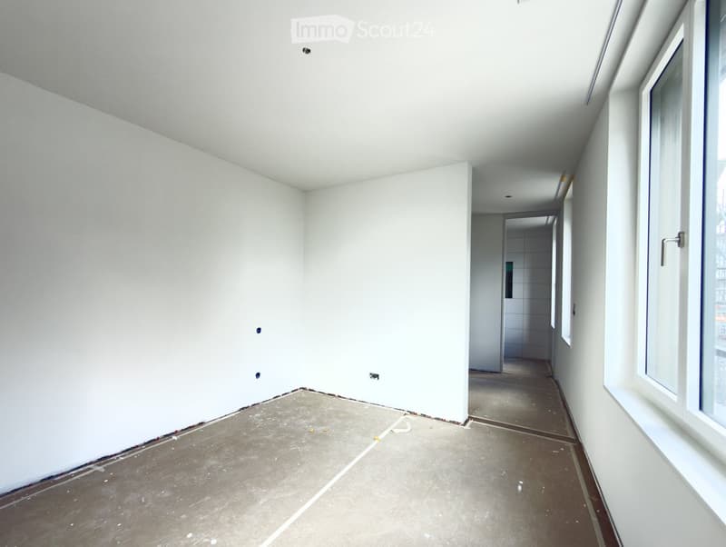 Empty room with white walls, concrete floor, and a window on the right side. No furniture or equipment present.