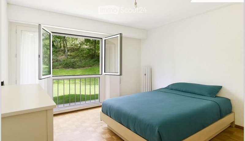 Bright bedroom with a wooden bed, teal bedding, and a large window with a view of a green outdoor area.