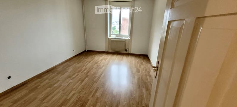 Empty room with wooden flooring, white walls, and a window with a radiator below it. No furniture or equipment is present.