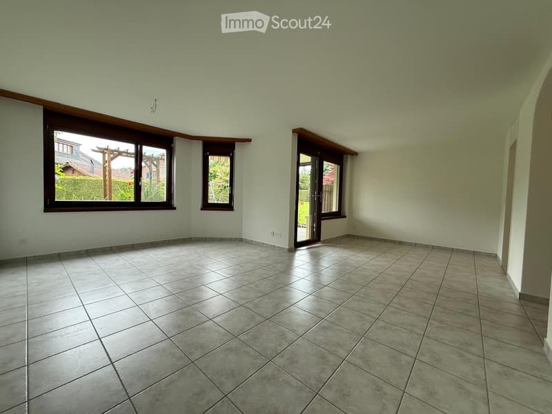 Empty room with tiled floor, large windows, and a door leading outside.