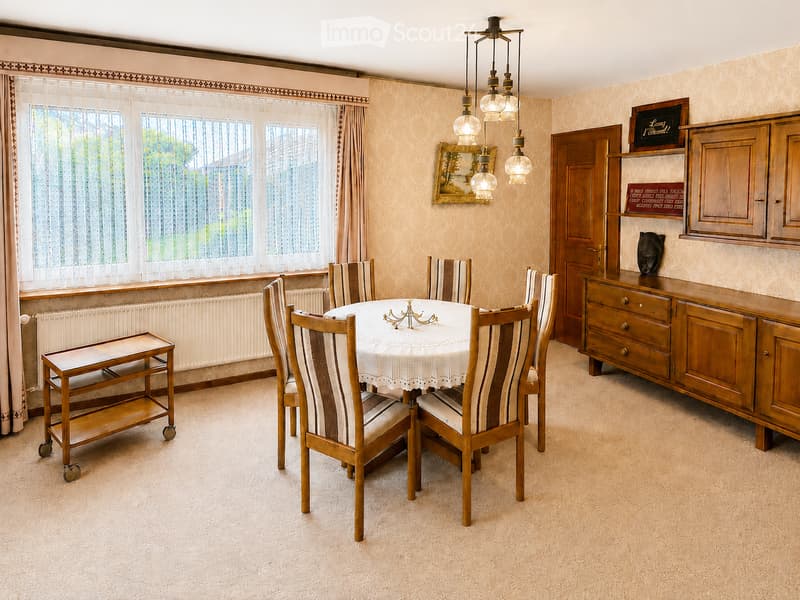 Dining room with a round table, six chairs, a side table, a wooden cabinet, and a mirror on the wall.