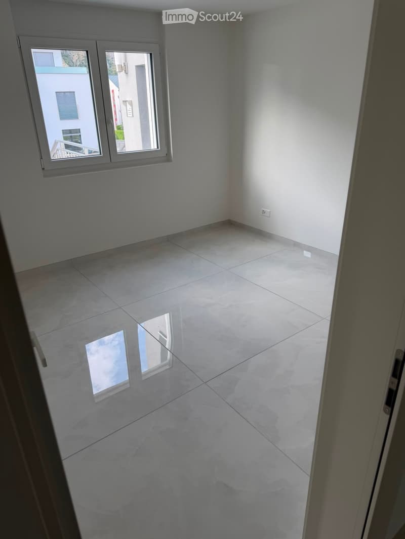 Empty room with white tiled floor and white walls, featuring two windows with white frames and blinds.