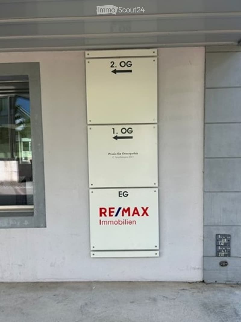 Exterior wall with directional signs indicating floors: EG (ground floor), 1. OG (first floor), and 2. OG (second floor).