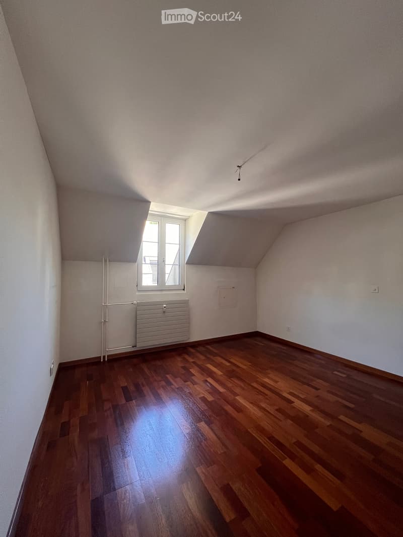 Empty room with wooden flooring, white walls, and a window with white frame. No furniture or equipment present.