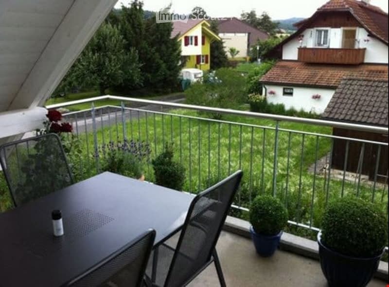 metal railings, black table, mesh chairs, green lawn, green plants