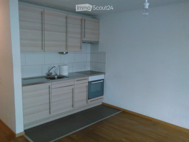 kitchen with cabinets, sink, oven, and tiled walls