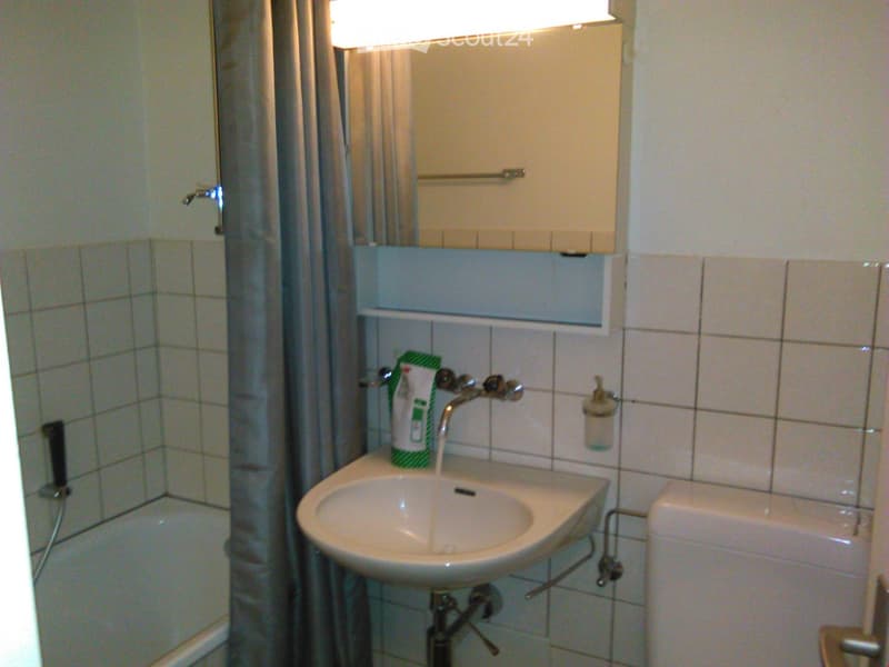 Bathroom with bathtub, sink, toilet, mirror, and shower curtain