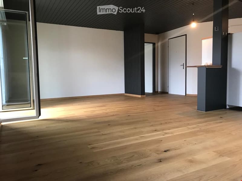 Empty room with wooden flooring, white walls, and large windows. No furniture or equipment present.