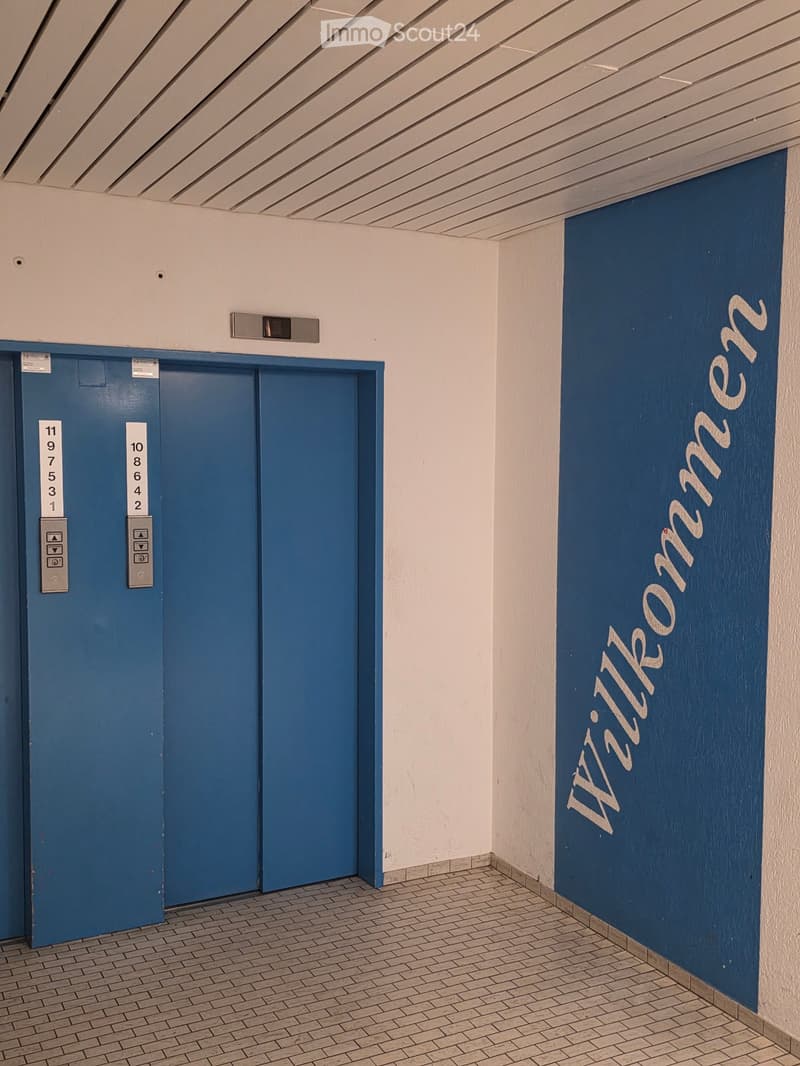elevator, wall with text 'Willkommen' in white