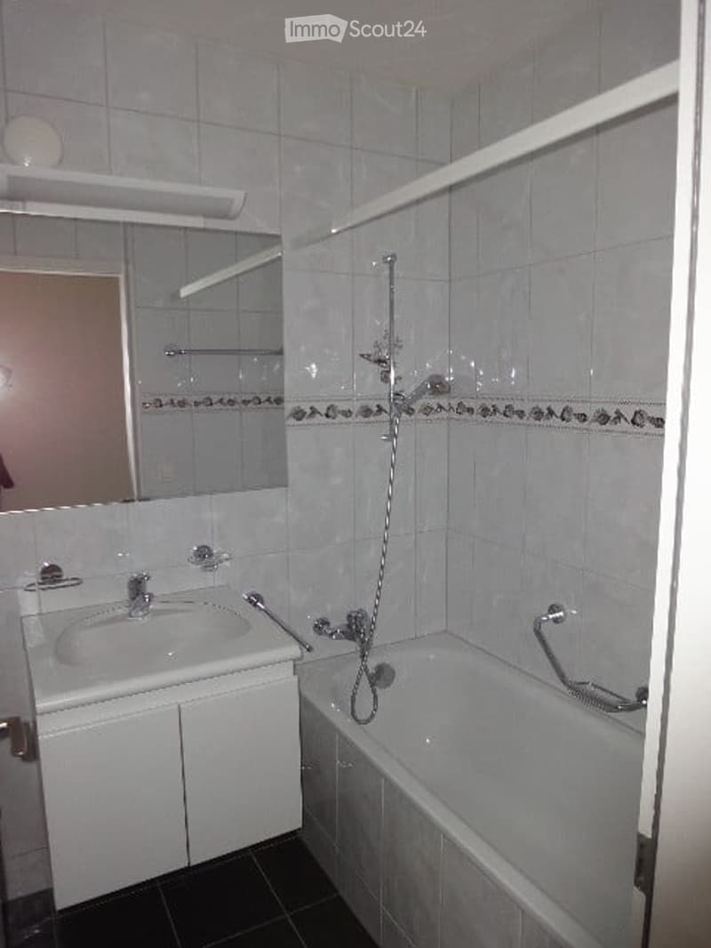 Bathroom: sink, bathtub, shower, mirror, white cabinets, white tiles